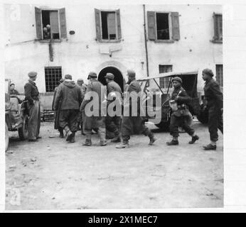 British soldiers escort German prisoners of war along a maritime quay ...