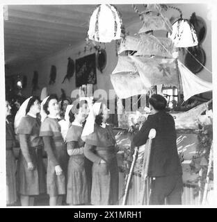 CHRISTMAS AT 104 BRITISH GENERAL HOSPITAL : OBSERVER STORY - Left to right:- Nursing Officer Mrs. C.E.P. Wilson of 9 King Edward Street, Alexandria, Dumbartonshire Nursing Officer Evelyn McCook of Killogie, Ballymoney, C.Antrim, N.Ireland. Nursing Officer M. Roche of Querrin, Ennis, Co.Clare, Ireland. Nursing Officer Anne Williams of 66 Culla Road, Trimsarum, Carmarthenshire Nursing Officer K.M. O'Reilly of New Street, Bantry, Co.Cork, Ireland Gnr. D. McKenna, R.A., of 161 Overgate Street, Dundee, British Army Stock Photo