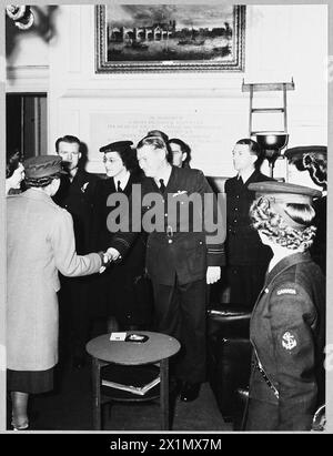 THE PRINCESS ROYAL MEETS ALLIED PERSONNEL AT CHURCHILL CLUB - H.R.H. the Princess Royal visited the Churchill Club, London, on 12th December 1944 and met many service men and women chiefly from Dominion and Allied countries. The Churchill Club was founded to promote better understanding between the service men and women of Britain, the Dominions and the Allies. Picture (issued 1944) shows - H.R.H. the Princess Royal shaking hands with Flight Lieutenant A.W. Roper, of the Royal Australian Air Force, of Sydney, New South Wales. He is a former New South Wales inter-State cricketer, who after a pe Stock Photo