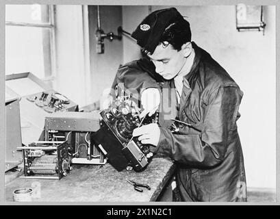 A Royal Air Force wireless mechanic refixes the panel of a wireless set following routine maintenance and inspection during World War II. Stock Photo
