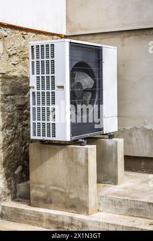 Air source heat pump installed outside of old renovated house, green renewable energy concept of heat pump Stock Photo
