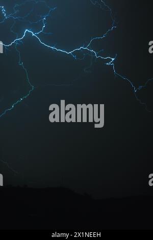 Big blue lightning striking the dark sky. Stock Photo