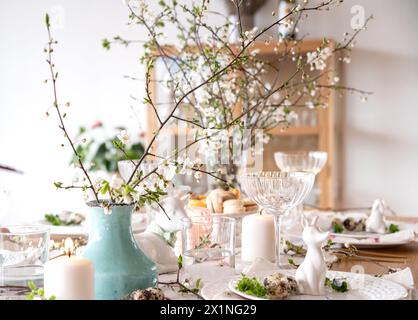 Spring Easter decor. Easter table setting. Flowers and dishes and candles for a festive dinner.  Stock Photo