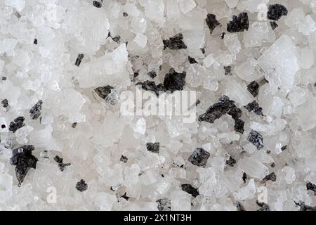 Heap of small stones of black salt on top of white salt, used in cooking seasonings Stock Photo