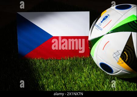 LEIPZIG, GERMANY, APRIL 17, 2024: Czech Republic national flag and official soccer ball of Euro 2024 football tournament in Germany placed on green gr Stock Photo