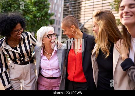 Meeting of diverse group of professionals business women in formal suit standing outdoors Stock Photo