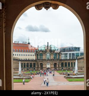 Zwinger palatial complex, a door framing the fountains in the courtyard with tourists. Dresden, Germany Stock Photo