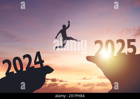 Silhouette of a man jumping from cliff to cliff Stock Photo