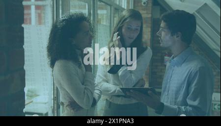 Diverse group of young adults discussing over tablet Stock Photo
