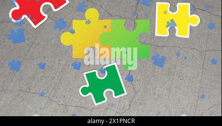Person not visible, only colorful puzzle pieces scattered on gray surface Stock Photo