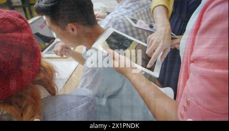 Group of diverse friends looking at tablet and laptop, collaborating Stock Photo