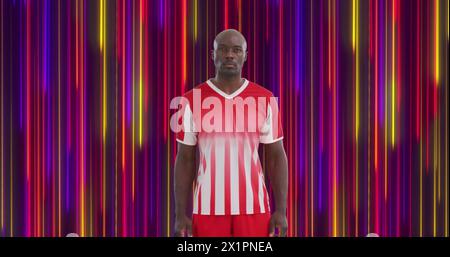 Man in striped sports kit stands against a colorful lined background Stock Photo