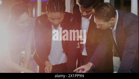 Diverse group of colleagues examining documents on table Stock Photo