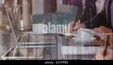 Diverse group of colleagues working together at table with laptops and coffee cups Stock Photo