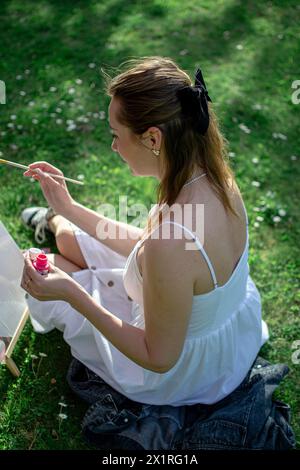 Female artist paints a picture with pink paints. Stock Photo