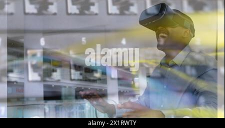 A middle-aged African American man wearing virtual reality headset, laughing Stock Photo