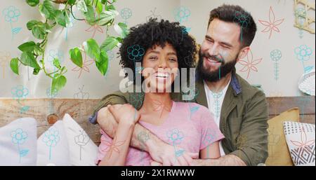 Diverse couple sitting together, biracial woman and Caucasian man laughing Stock Photo