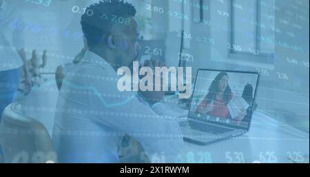 A diverse team of colleagues focusing on work, one holding business paper Stock Photo
