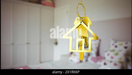 A golden house-shaped keychain hanging in focus with blurred bedroom background Stock Photo