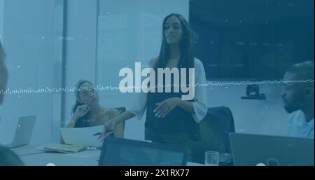 Diverse group of friends discussing in office, one holding tablet Stock Photo