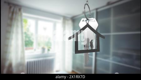 A keychain in shape of house containing keys hanging in focus Stock Photo