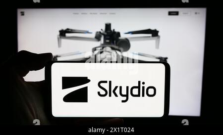 Person holding smartphone with logo of US drone manufacturing company Skydio Inc. in front of website. Focus on phone display. Stock Photo