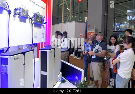 (240418) -- GUANGZHOU, April 18, 2024 (Xinhua) -- Purchasers learn about solar power generation equipment during the 135th session of the China Import and Export Fair in Guangzhou, south China's Guangdong Province, April 16, 2024. Electric vehicles, solar batteries and lithium-ion batteries, categorized as China's tech-intensive and green 'new three,' reported a combined export value of 1.06 trillion yuan (150 billion dollars) in 2023, jumping 29.9 percent year on year. Lots of exhibitors in the related industries showcase various products in the ongoing 135th session of the China Import and E Stock Photo