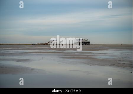 Salt and Silver Restaurant Cafe near St. Peter Ording with toilet pile dwelling in the distance in the evening, beach with water in front North Sea, G Stock Photo