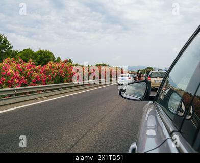 Strasbourg, France - Jun 28, 2023: View from a car on a Mallorcan highway, flanked by vibrant pink flowers and summer traffic Stock Photo
