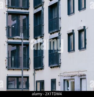 Apartment building house renovation featuring new window installations, balconies, and improved insulation. Stock Photo