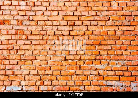 wide pattern of an orange brick wall. not finished or abandoned architecture development concept. dirty and uneven texture Stock Photo