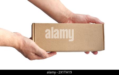 One rectangular cardboard box in hands on a plain light background. No recognizable people Stock Photo