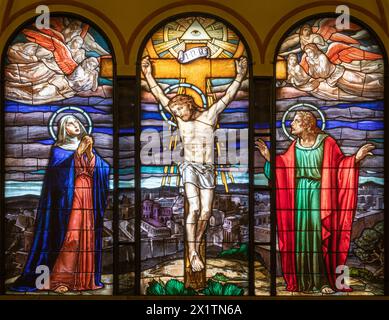 MILAN, ITALY - MARCH 4, 2024: The Calvary in the stained glass in the church Chiesa di San Agostino from year (1950). Stock Photo