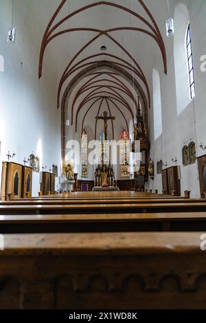 Interior view of a church with wooden pews and coloured stained glass windows, Bad Reichenhall, Bavaria, Germany Stock Photo