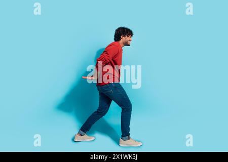 Full body profile portrait of struggling hardworking person arms carry heavy empty space isolated on blue color background Stock Photo
