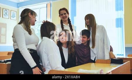 High school seniors hugging in class. Stock Photo