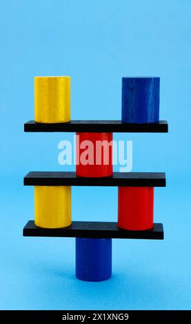 Colorful cylinders balanced on a support point Stock Photo