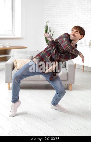 Young tattooed man dancing at home Stock Photo