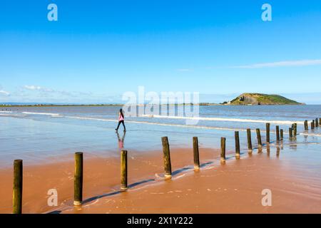 Young woman walking alone on deserted beach Stock Photo