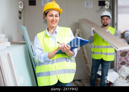 Smiling female civil engineer with documents at construction site Stock Photo