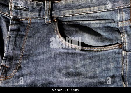 top of old dark blue men's jeans, front pocket close-up, signature yellow double stitching, concept of masculinity, everyday fashion Stock Photo