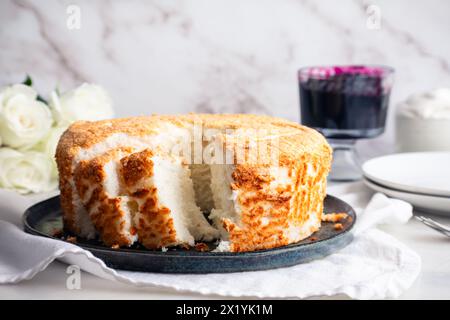 Sliced Angel Food Cake with Blueberry Sauce and Whipped Cream: Slices of sponge cake served with blueberry jam and chantilly cream on the side Stock Photo