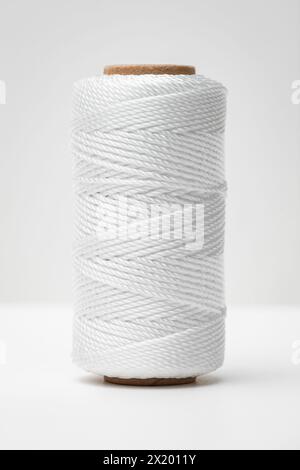 Nylon twine strings bobbin spool cord reel thread cylinder silky white background Stock Photo