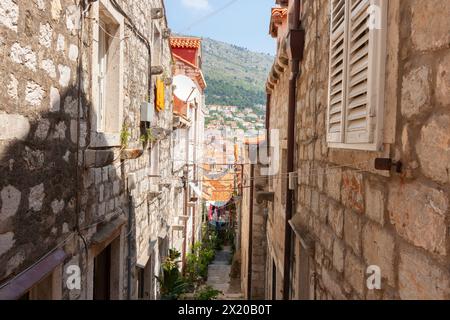 View-shaft between old stone apartments along narrow alley to hills and building beyond in Old Town of Dubrovnik Croatia. Stock Photo