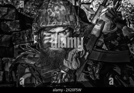 Stop war and russian aggression in Ukraine. Ukraine on military uniform. Close up portrait face of ukrainian soldier with assault rifle AK. Tired Stock Photo