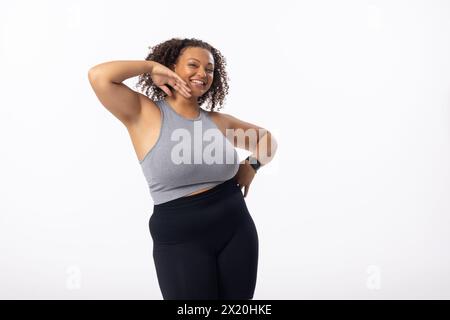 A biracial young female plus size model poses on white background, copy space Stock Photo