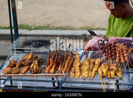 A BBQ vendor selling grilled skewers of meat and seafood in Hoi An, Vietnam. Stock Photo