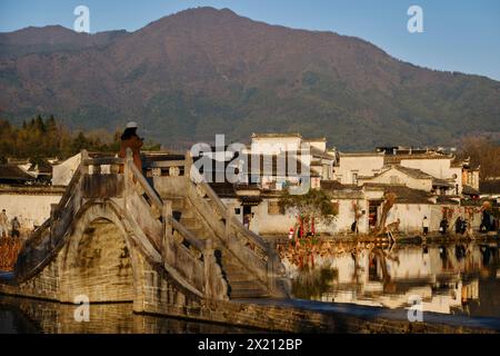 A woman uses her mobile phone on a bridge at Hongcun village in Anhui Province, China December 24, 2023. Photo by Tim Chong Stock Photo