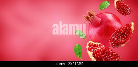 Pomegranate with slice and leafs flying on pomegranate colour background. Background for label, package design Stock Photo