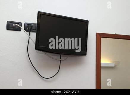 wall mounted lcd tv and mirror in motel room Stock Photo